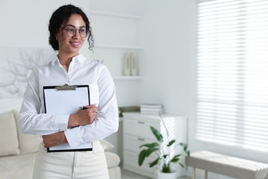 Photo of Professional psychologist with clipboard and pen in office, space for text