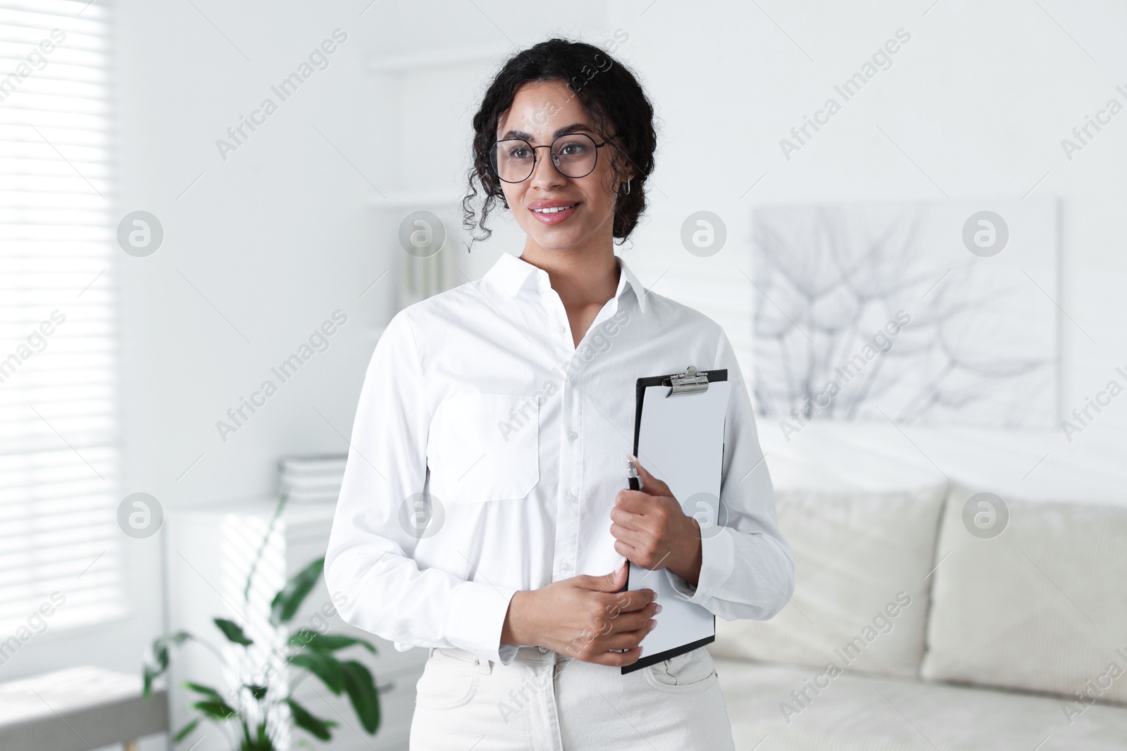 Professional psychologist with clipboard and pen in office Photo of Professional psychologist with clipboard and pen in office