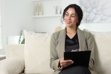 Photo of Professional psychologist with clipboard in office, space for text