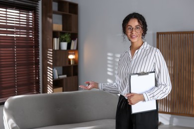 Photo of Professional psychologist with clipboard and pen in office, space for text