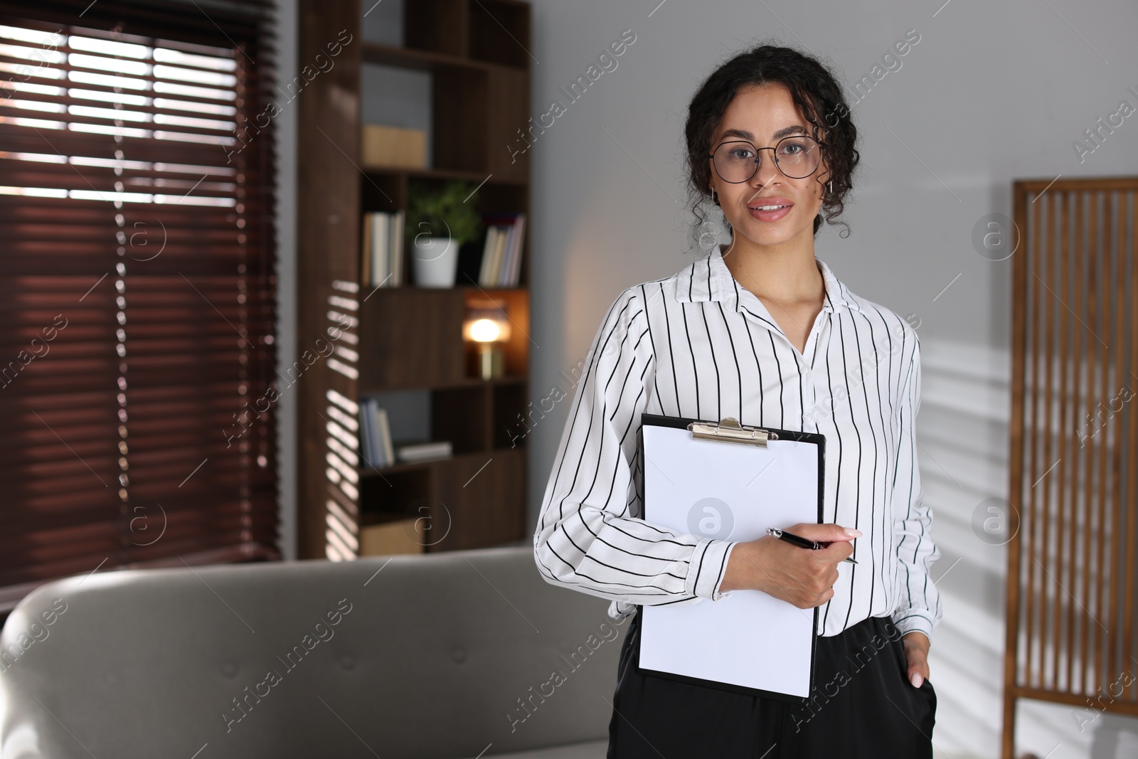 Professional psychologist with clipboard and pen in office, space for text Photo of Professional psychologist with clipboard and pen in office, space for text