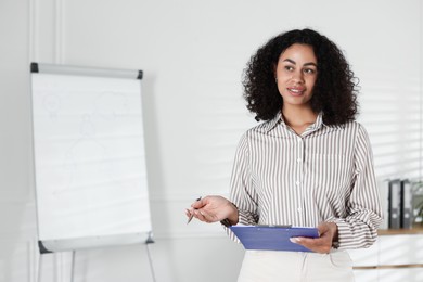 Photo of Professional psychologist with clipboard and pen in office, space for text