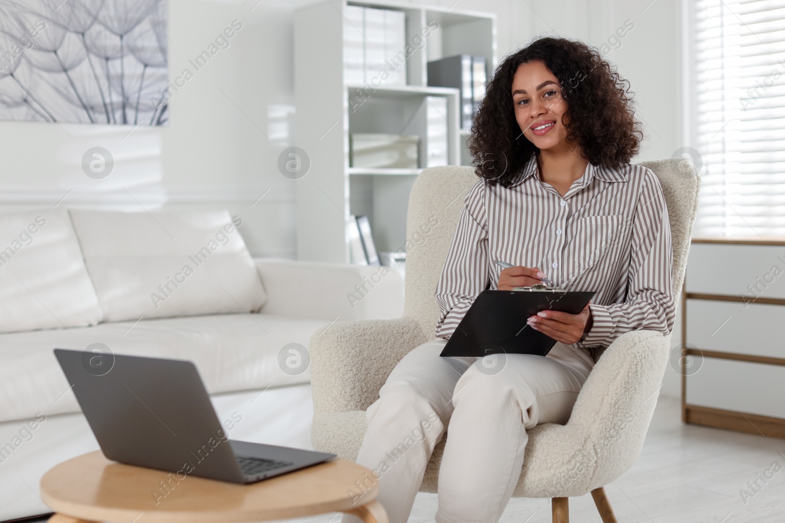 Professional psychologist with clipboard and pen in office Photo of Professional psychologist with clipboard and pen in office
