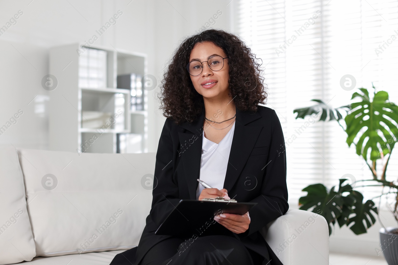Professional psychologist with clipboard and pen in office Photo of Professional psychologist with clipboard and pen in office
