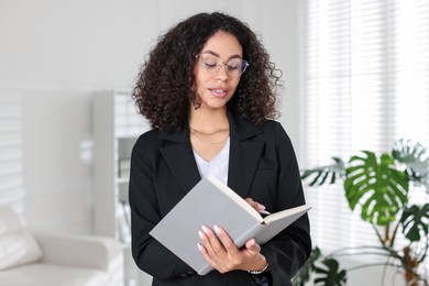 Photo of Professional psychologist with notebook and pen in office
