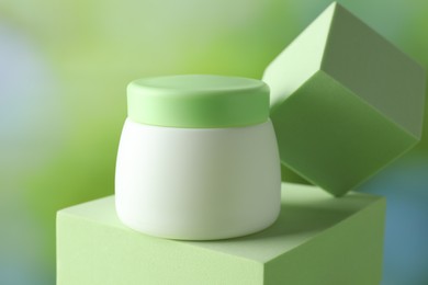 Photo of Stylish presentation of body cream in jar on blurred background, closeup