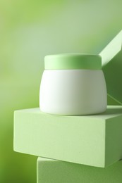 Photo of Stylish presentation of body cream in jar on blurred background, closeup