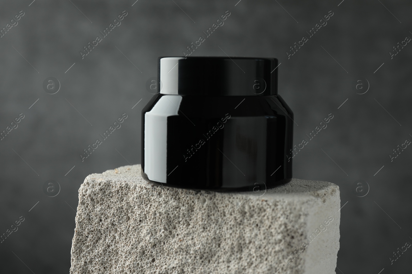 Jar of body cream on stone against grey background, closeup Photo of Jar of body cream on stone against grey background, closeup