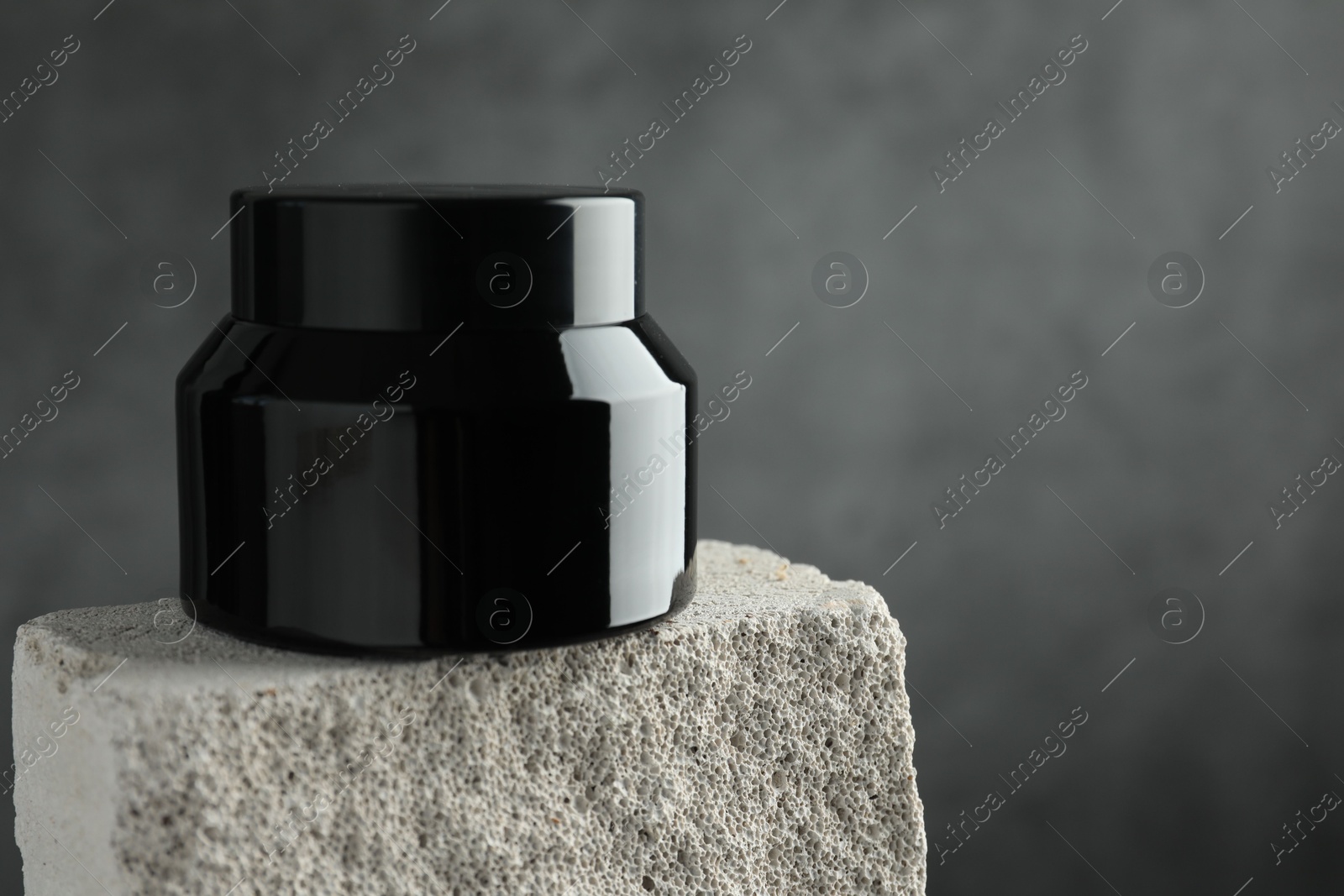 Jar of body cream on stone against grey background, closeup. Space for text Photo of Jar of body cream on stone against grey background, closeup. Space for text