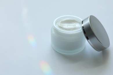Photo of Jar of body cream on white background, closeup. Space for text