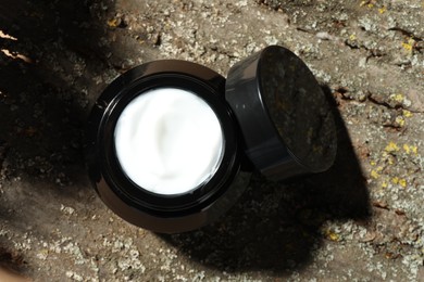 Photo of Jar of body cream on tree bark, top view