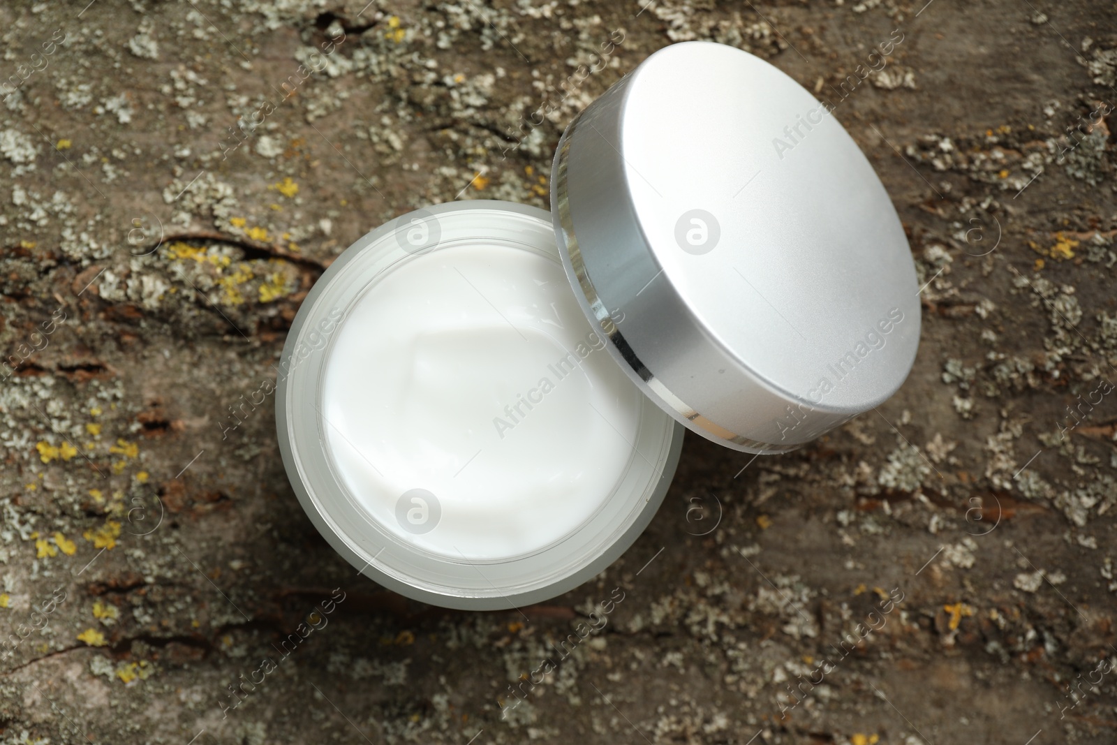 Jar of body cream on tree bark, top view Photo of Jar of body cream on tree bark, top view