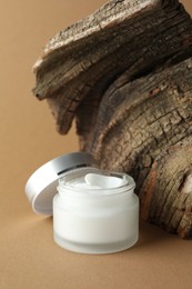 Photo of Jar of body cream on beige background