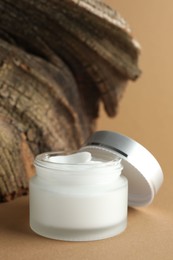 Photo of Jar of body cream on beige background, closeup