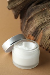 Photo of Jar of body cream on beige background, closeup