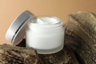 Photo of Jar of body cream on beige background, closeup