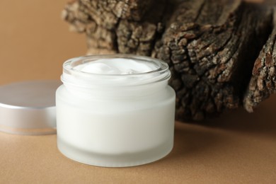 Photo of Jar of body cream on beige background, closeup