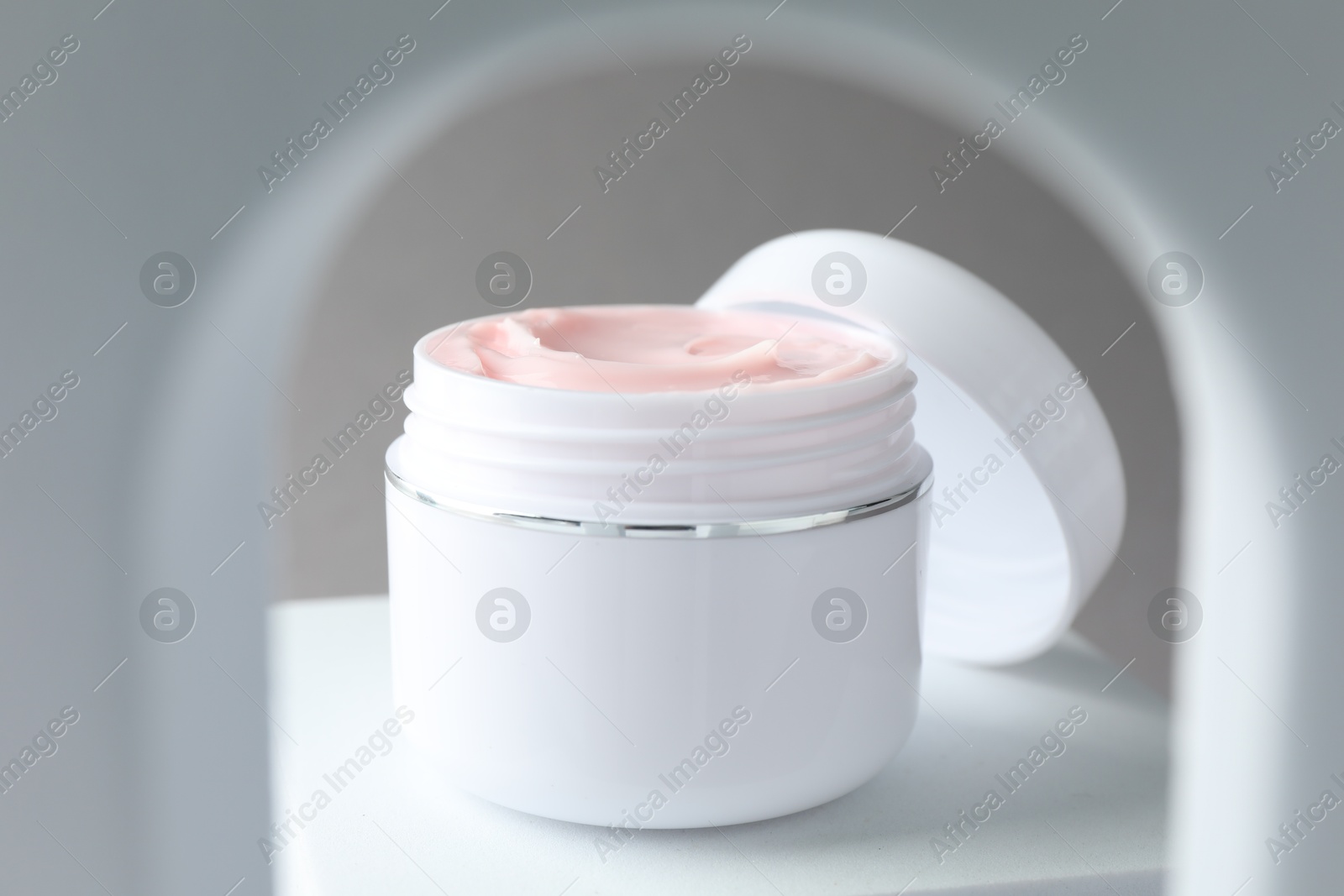 Stylish presentation of body cream in jar on light grey background, closeup Photo of Stylish presentation of body cream in jar on light grey background, closeup