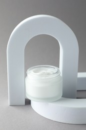 Photo of Stylish presentation of body cream in jar on light grey background
