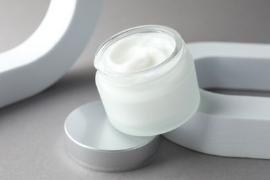 Photo of Stylish presentation of body cream in jar on light grey background, closeup