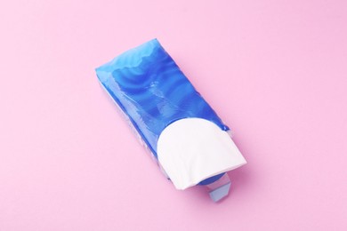 Photo of Paper handkerchiefs in package on pink background