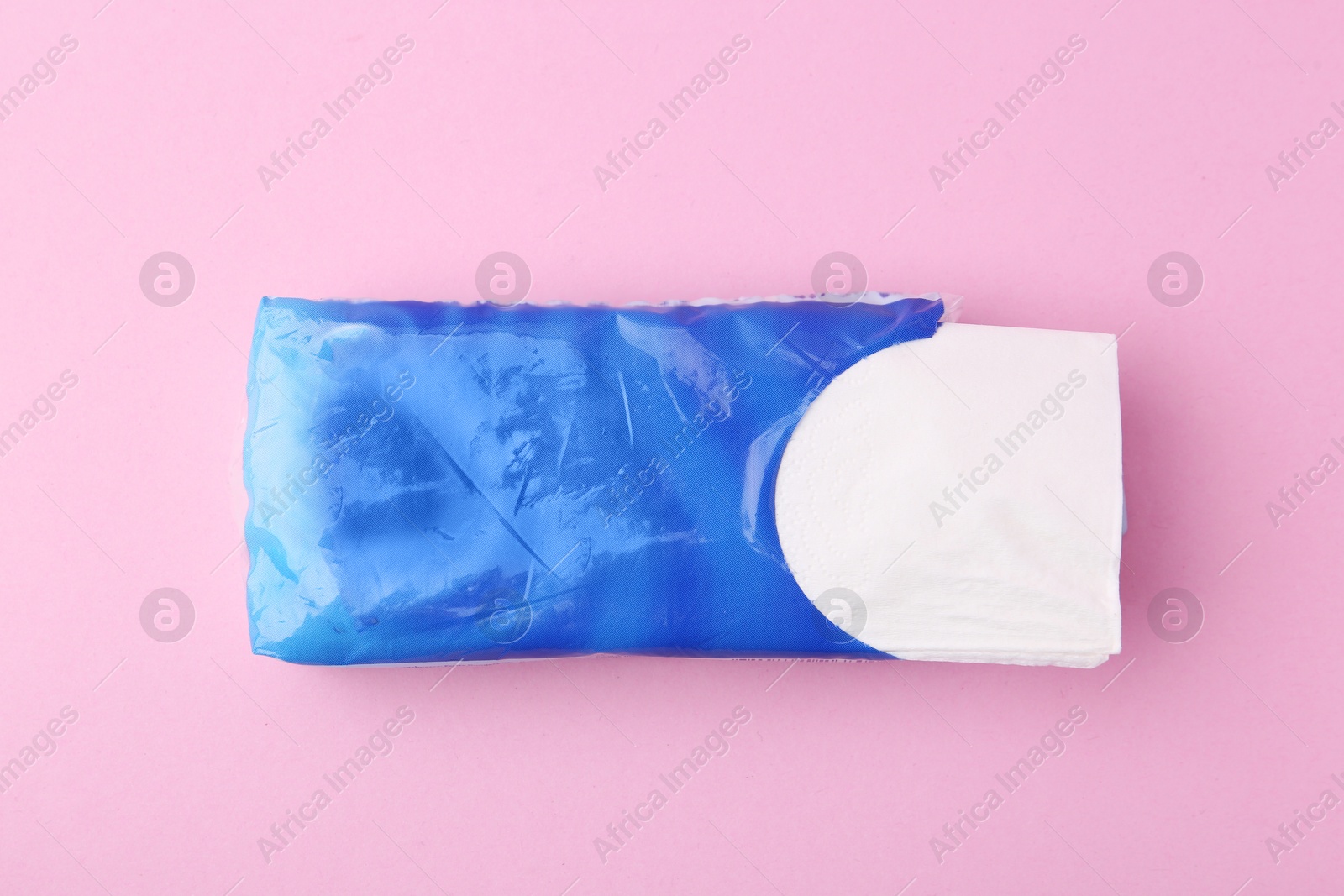 Paper handkerchiefs in package on pink background, top view Photo of Paper handkerchiefs in package on pink background, top view