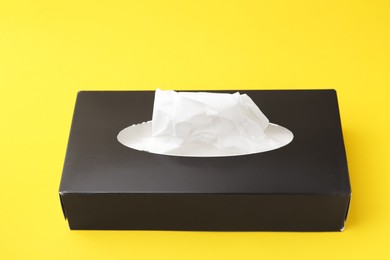 Photo of Box with paper handkerchiefs on yellow background