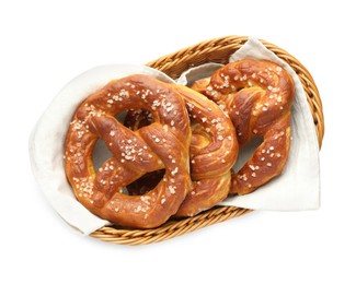 Photo of Tasty pretzels with salt in wicker basket isolated on white, top view