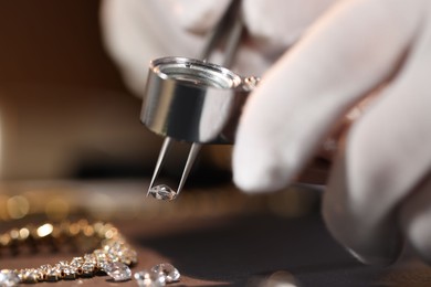 Photo of Appraiser with loupe evaluating gemstone at table indoors, closeup