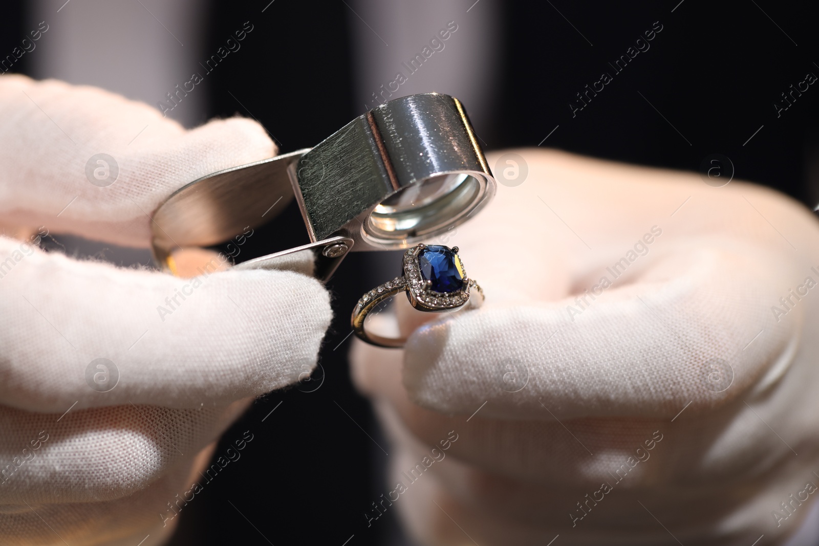 Appraiser with loupe evaluating ring indoors, closeup Photo of Appraiser with loupe evaluating ring indoors, closeup