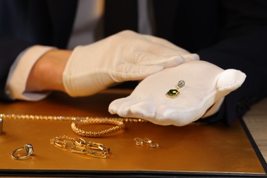 Photo of Appraiser working with luxury earring at table, closeup