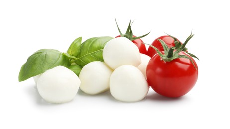 Photo of Tasty mozzarella cheese balls, tomatoes and basil isolated on white