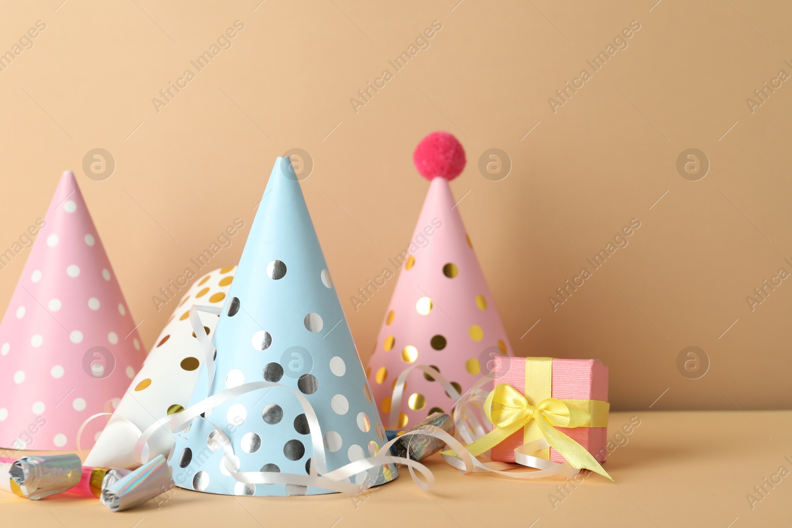 Party hats and festive decor on beige background Photo of Party hats and festive decor on beige background