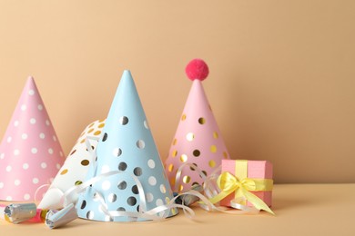 Photo of Party hats and festive decor on beige background