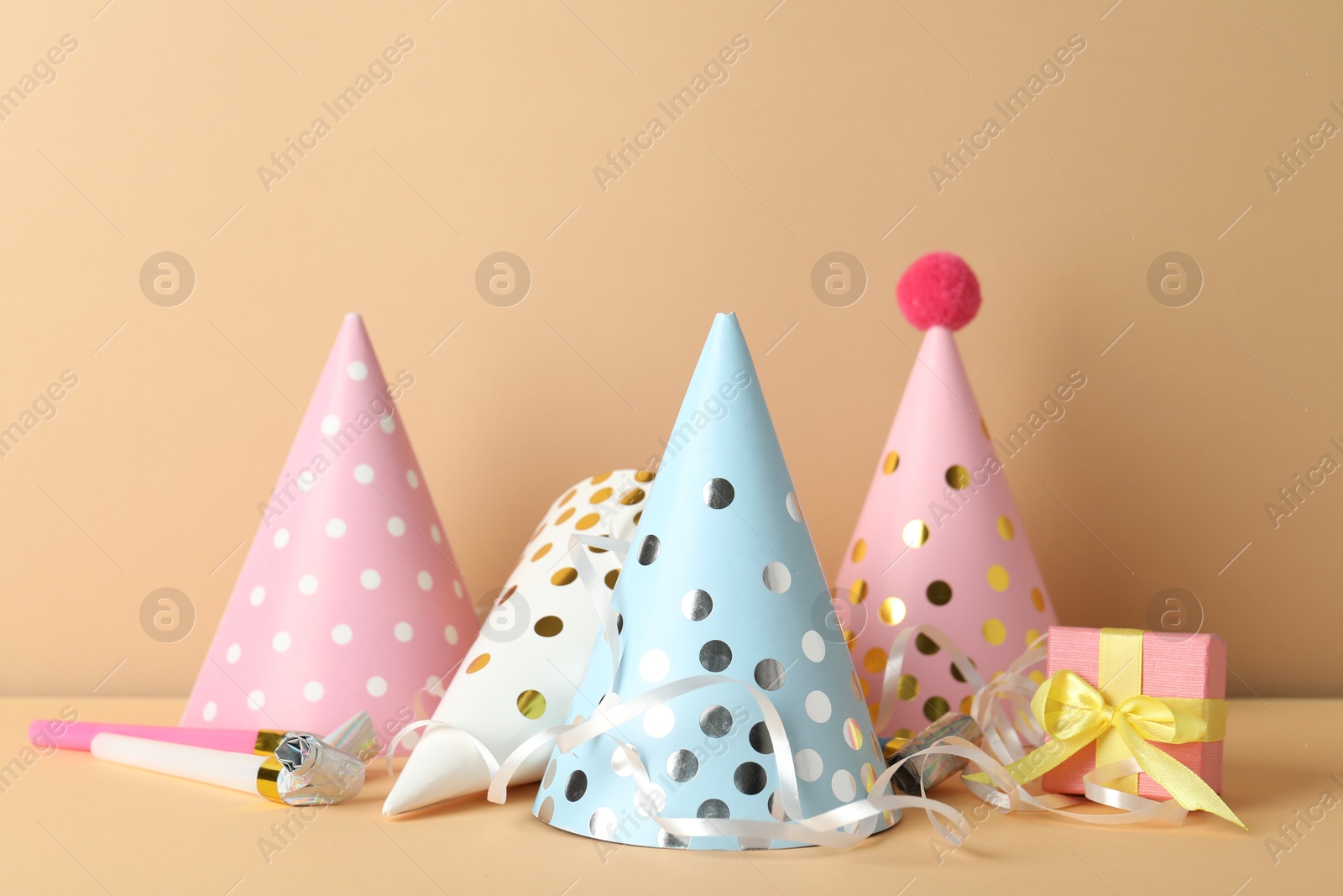 Party hats and festive decor on beige background Photo of Party hats and festive decor on beige background