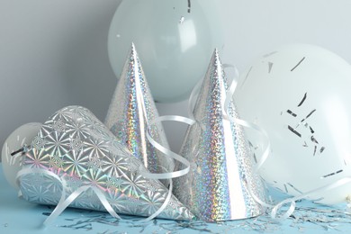 Photo of Party hats and festive decor on color background