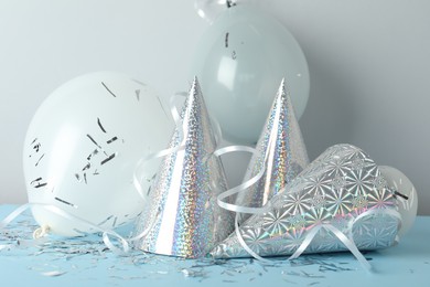 Photo of Party hats and festive decor on color background