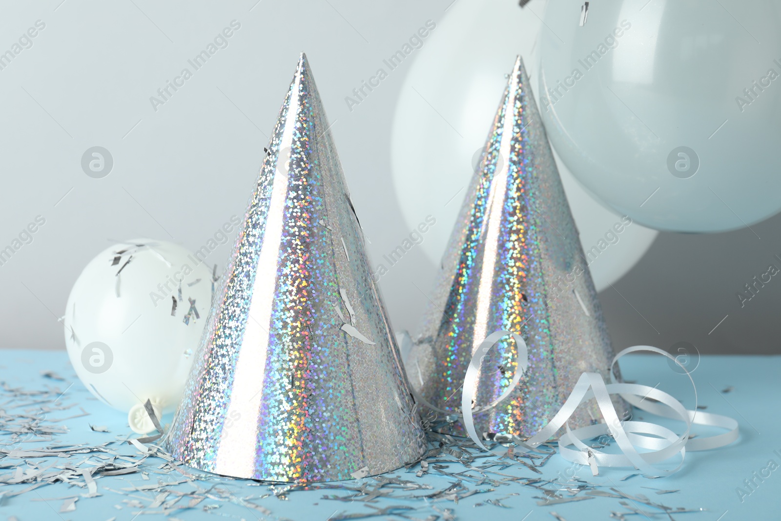 Party hats and festive decor on color background Photo of Party hats and festive decor on color background