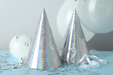 Photo of Party hats and festive decor on color background