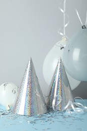 Photo of Party hats and festive decor on color background
