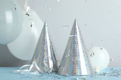 Photo of Party hats and festive decor on color background