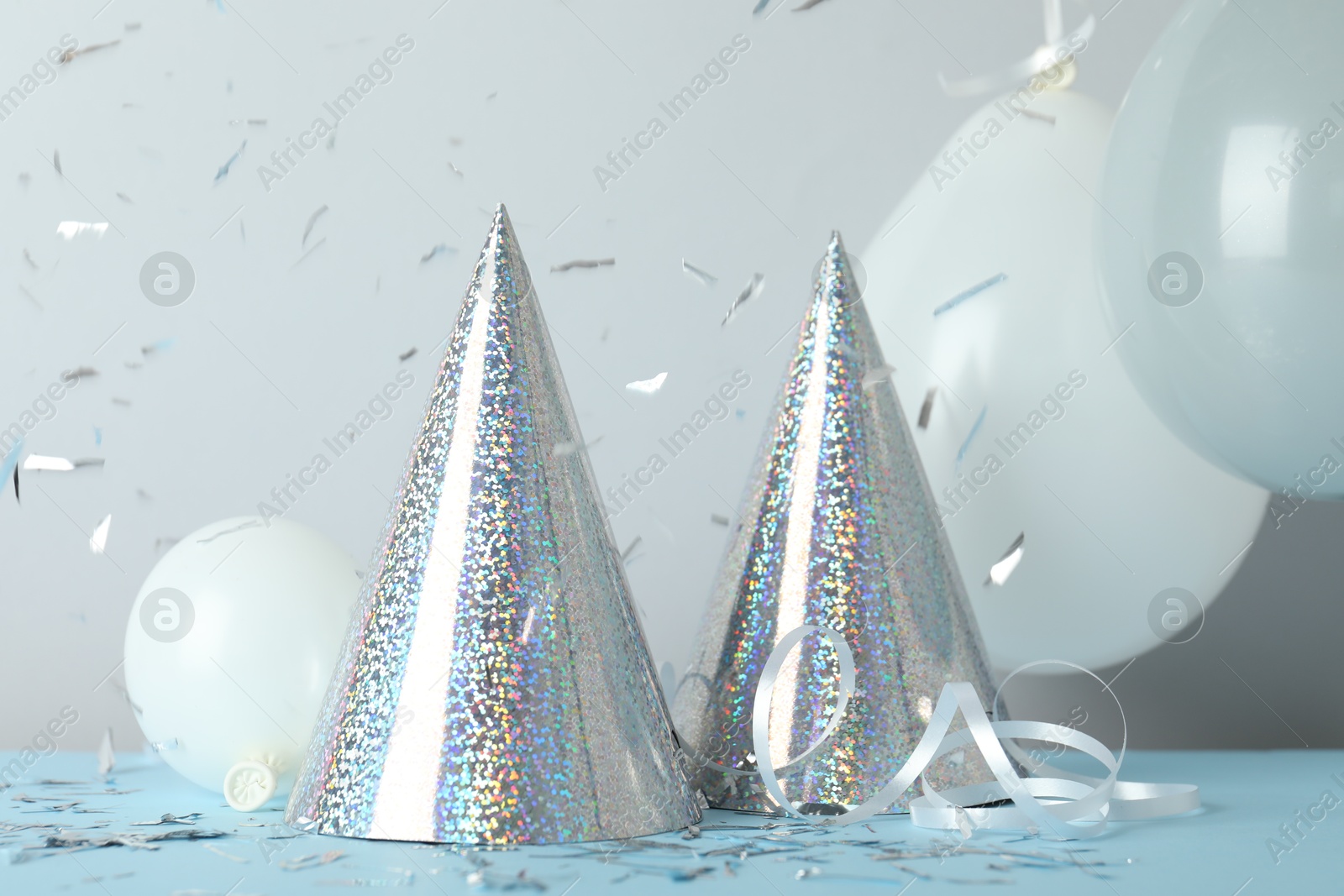 Party hats and festive decor on color background Photo of Party hats and festive decor on color background