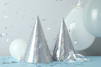 Photo of Party hats and festive decor on color background
