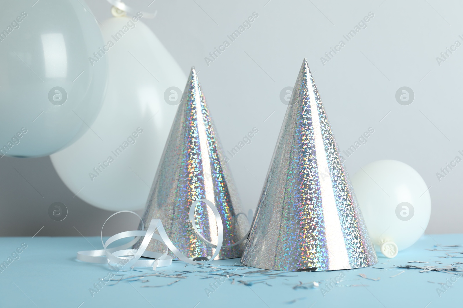 Party hats and festive decor on color background Photo of Party hats and festive decor on color background
