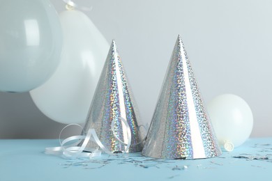 Photo of Party hats and festive decor on color background