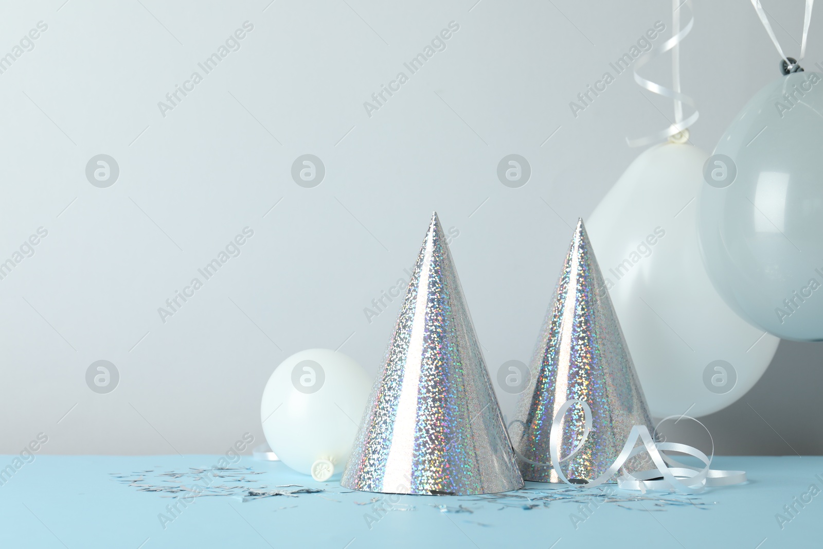 Party hats and festive decor on color background. Space for text Photo of Party hats and festive decor on color background. Space for text
