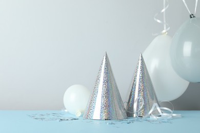 Photo of Party hats and festive decor on color background. Space for text