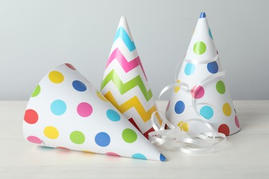 Photo of Party hats and festive decor on light background