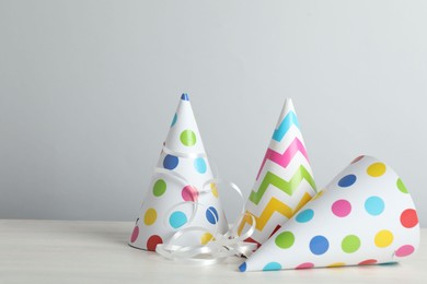 Photo of Party hats and festive decor on light background. Space for text