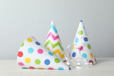 Photo of Party hats and festive decor on light background